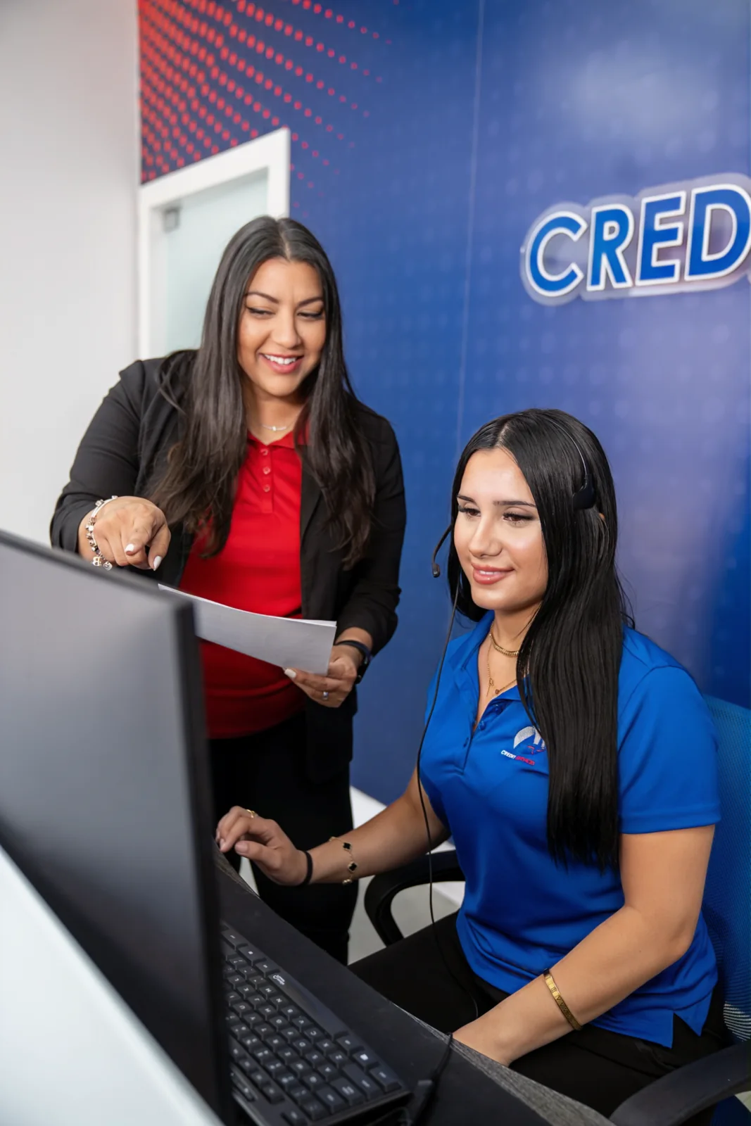 Una especialista de A Plus Credit Services revisa el reporte de crédito con un cliente