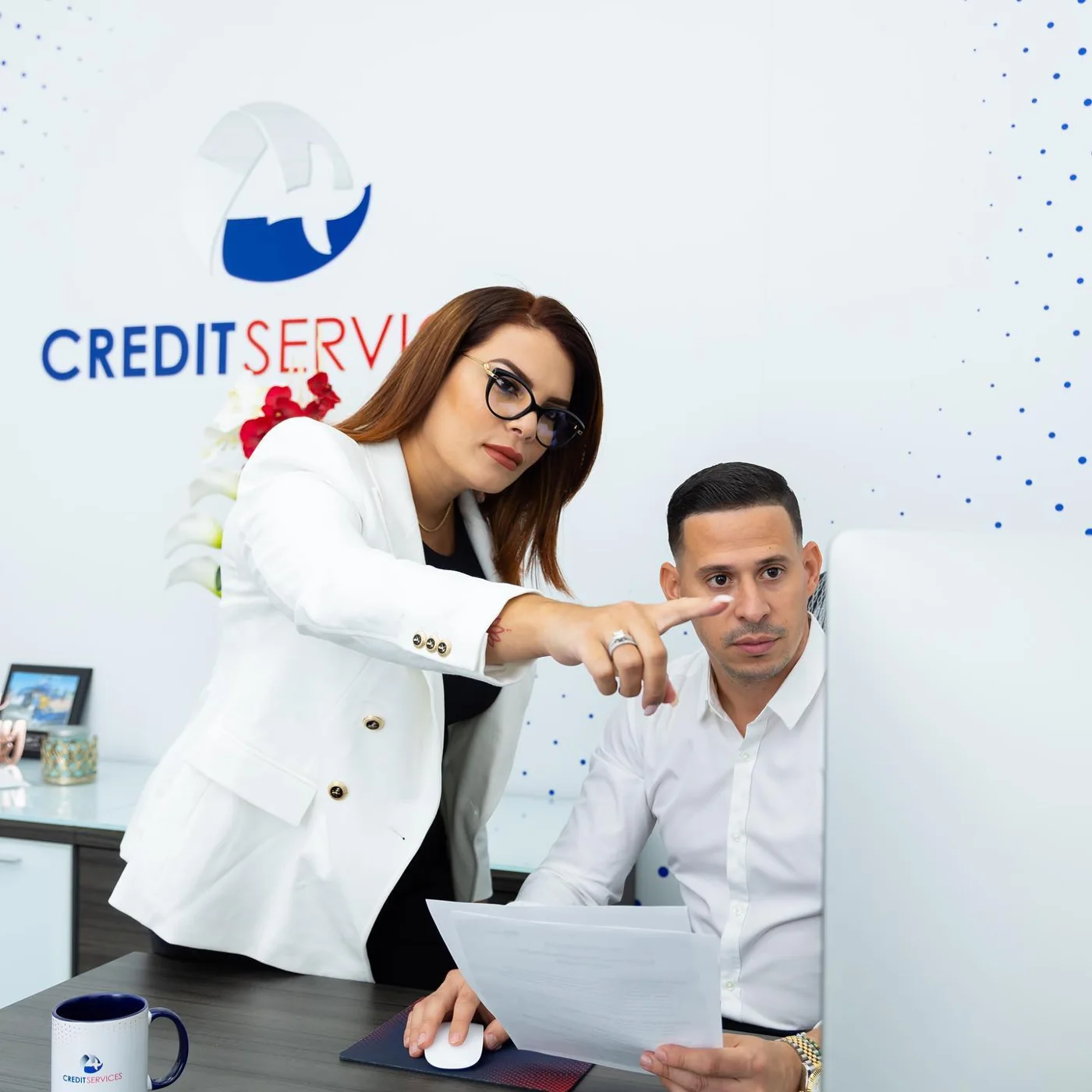 Adony and Yeni Pérez reviewing documents together at their office computer